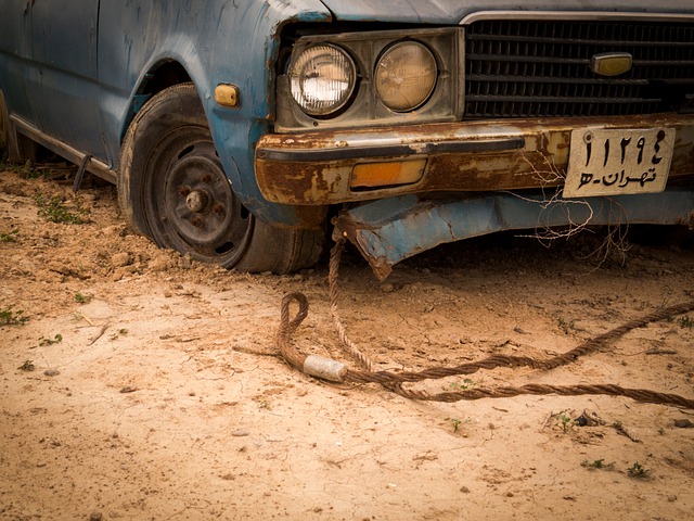 Staré auto, na ktorom je pripnuté ťažné lano